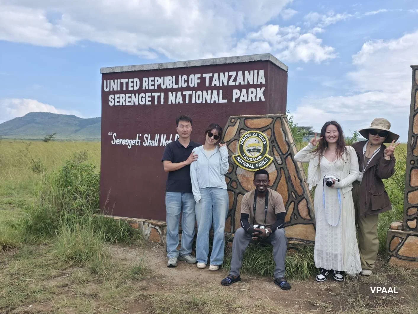 Travellers at the Serengeti National Park boundary sign
